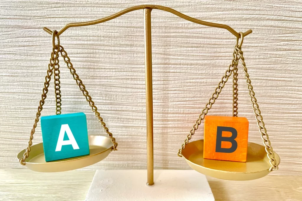 電気製品の優先順位を天秤で比較するイメージ。災害時の停電対策で使う家電の重要度を視覚化。